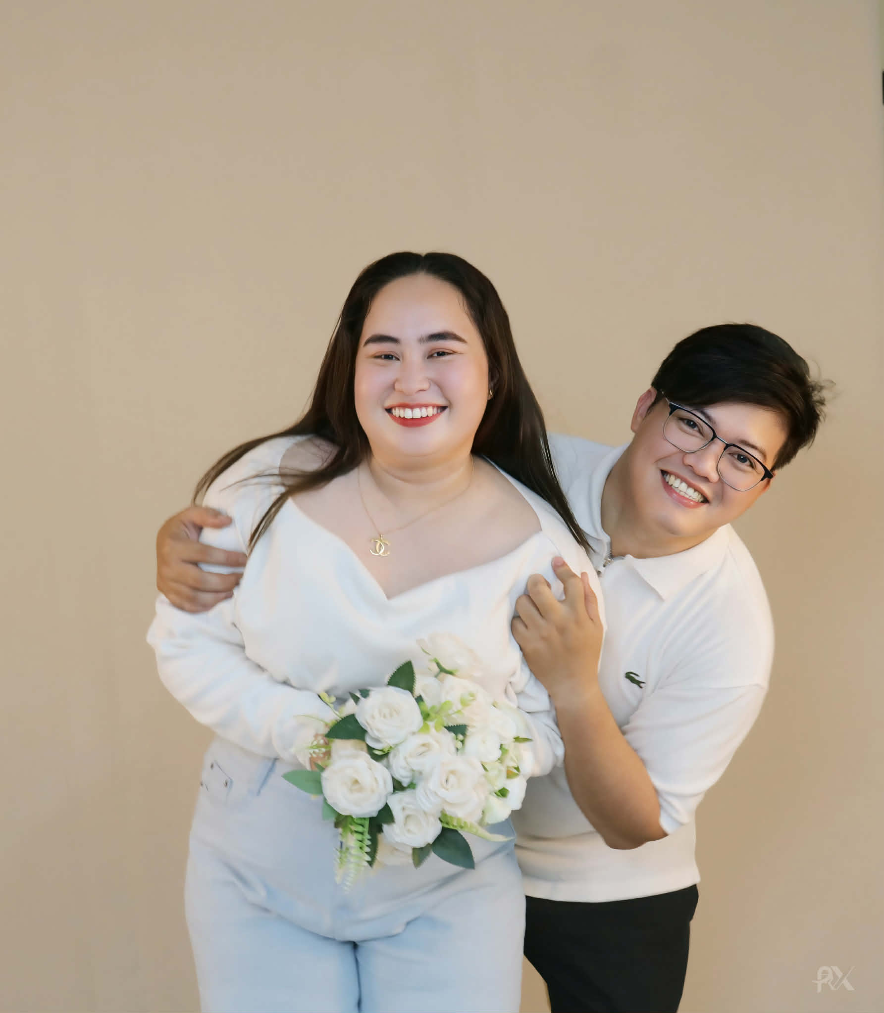 Ryan and Margorie smiling together, with Margorie holding a bouquet of white roses